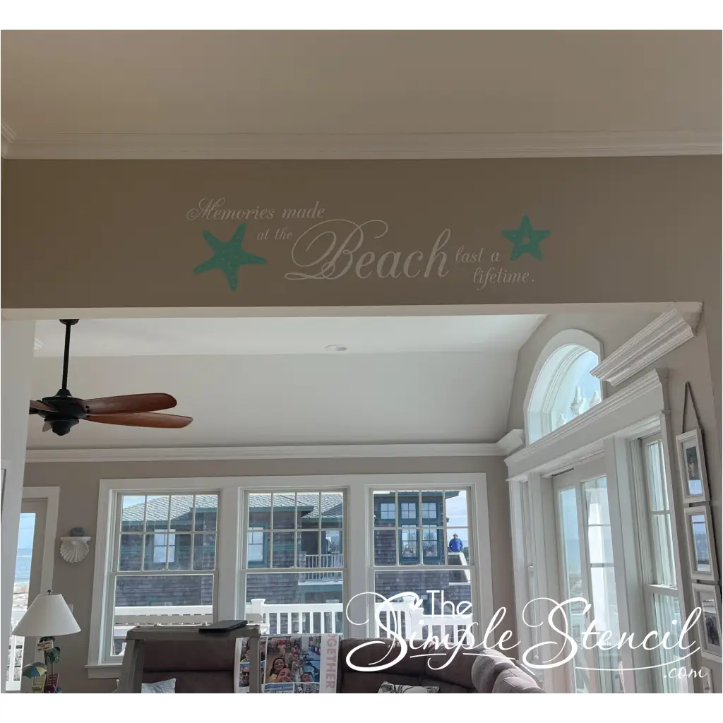 A charming wall decal adorns the sun-drenched interior of a beachfront home, its message "Memories made at the beach last a lifetime" resonating with the picturesque ocean view beyond. Two playful starfish graphics, their delicate forms reminiscent of seaside treasures, complement the heartfelt sentiment, capturing the essence of enduring coastal memories.