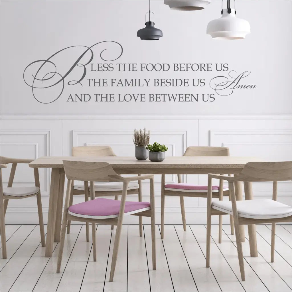 A beautifully scripted wall decal that quotes: Bless the food before us, the family beside us and the love between us. Amen. - By The Simple Stencil