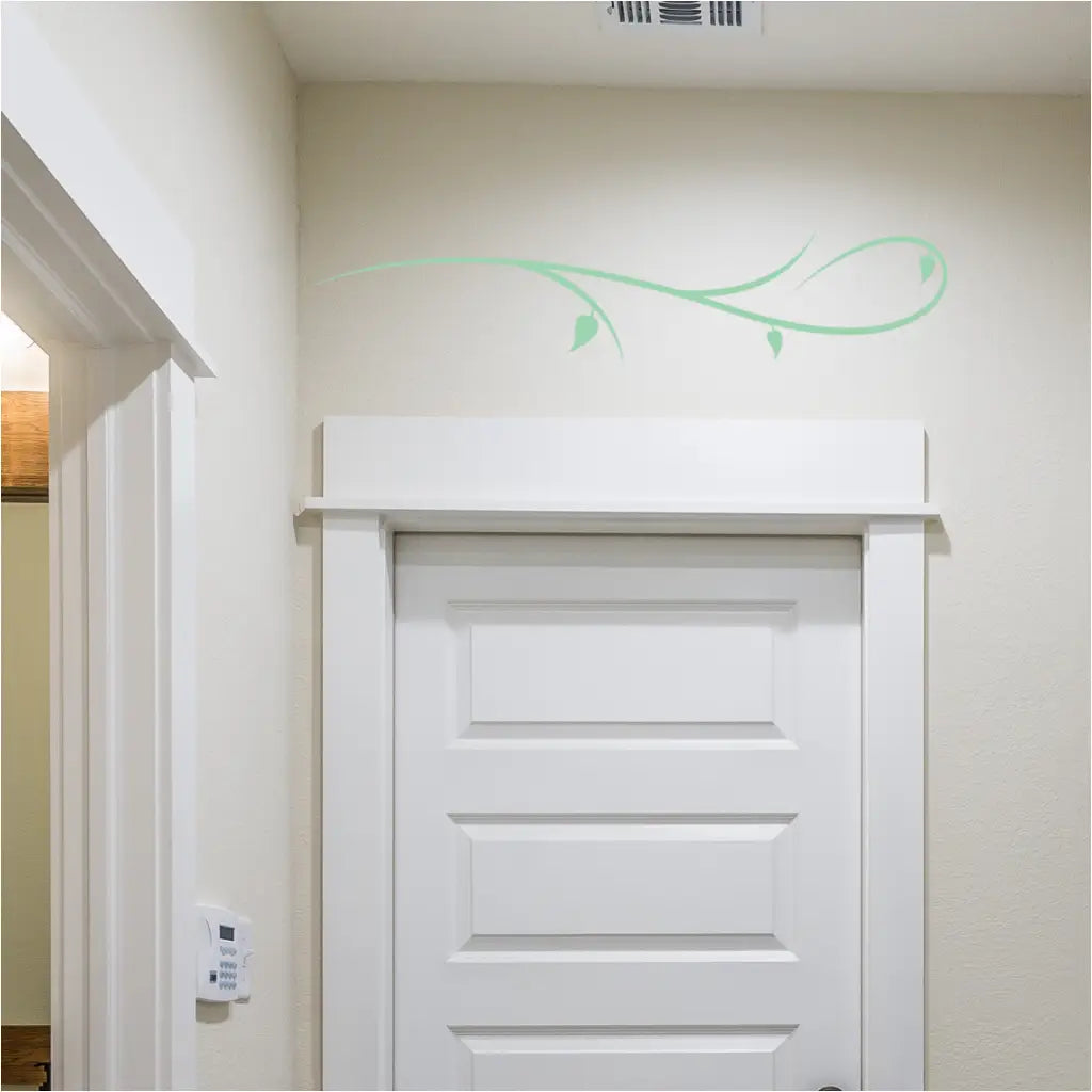 Simple branch flourish decal applied to a clean white wall, showcasing its elegant curve.