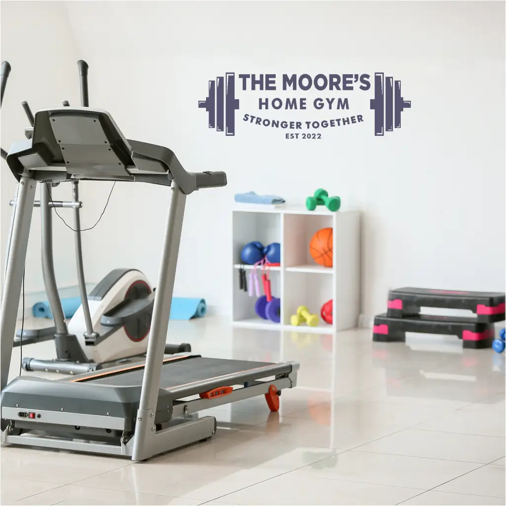 Image of a home gym with the decal prominently displayed above a workout bench, illustrating its motivational impact. This personalized home gym decal includes barbell graphic and the words Stronger Together with optional Est. Year. By TheSimpleStencil.com