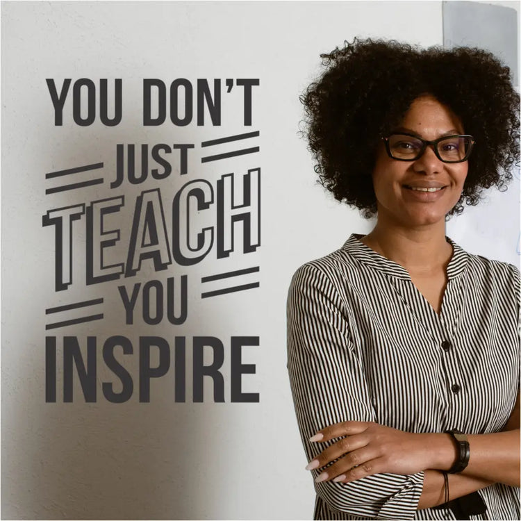 A teacher reading the "You Don't Just Teach, You Inspire" wall decal.