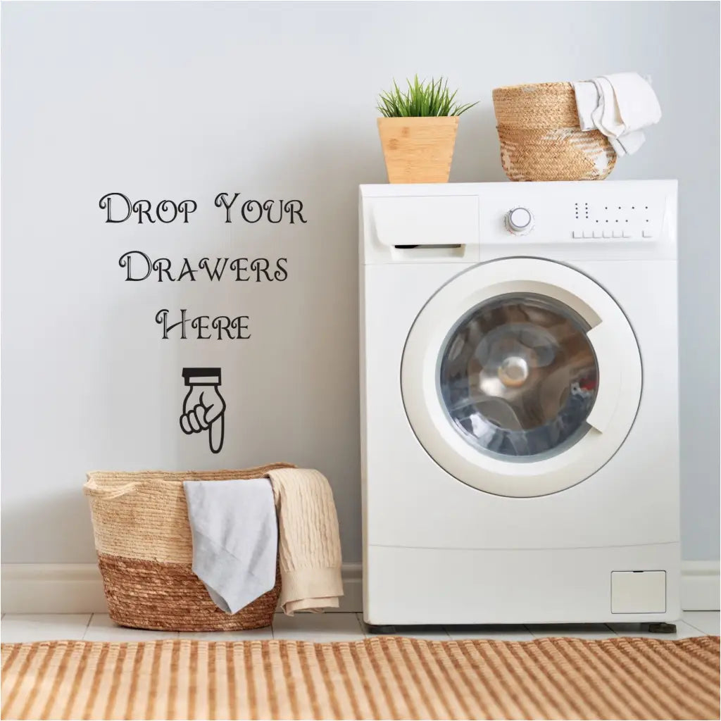 A cute wall decal display for your laundry room that reads: Drop your drawers here. includes a cute hand pointing to hamper.