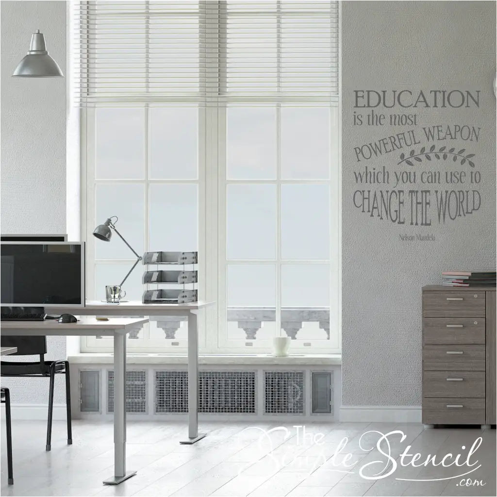 A vinyl wall decal in a large classroom setting with black text on a light-colored background: "Education is the most powerful weapon which you can use to change the world. - Nelson Mandela"