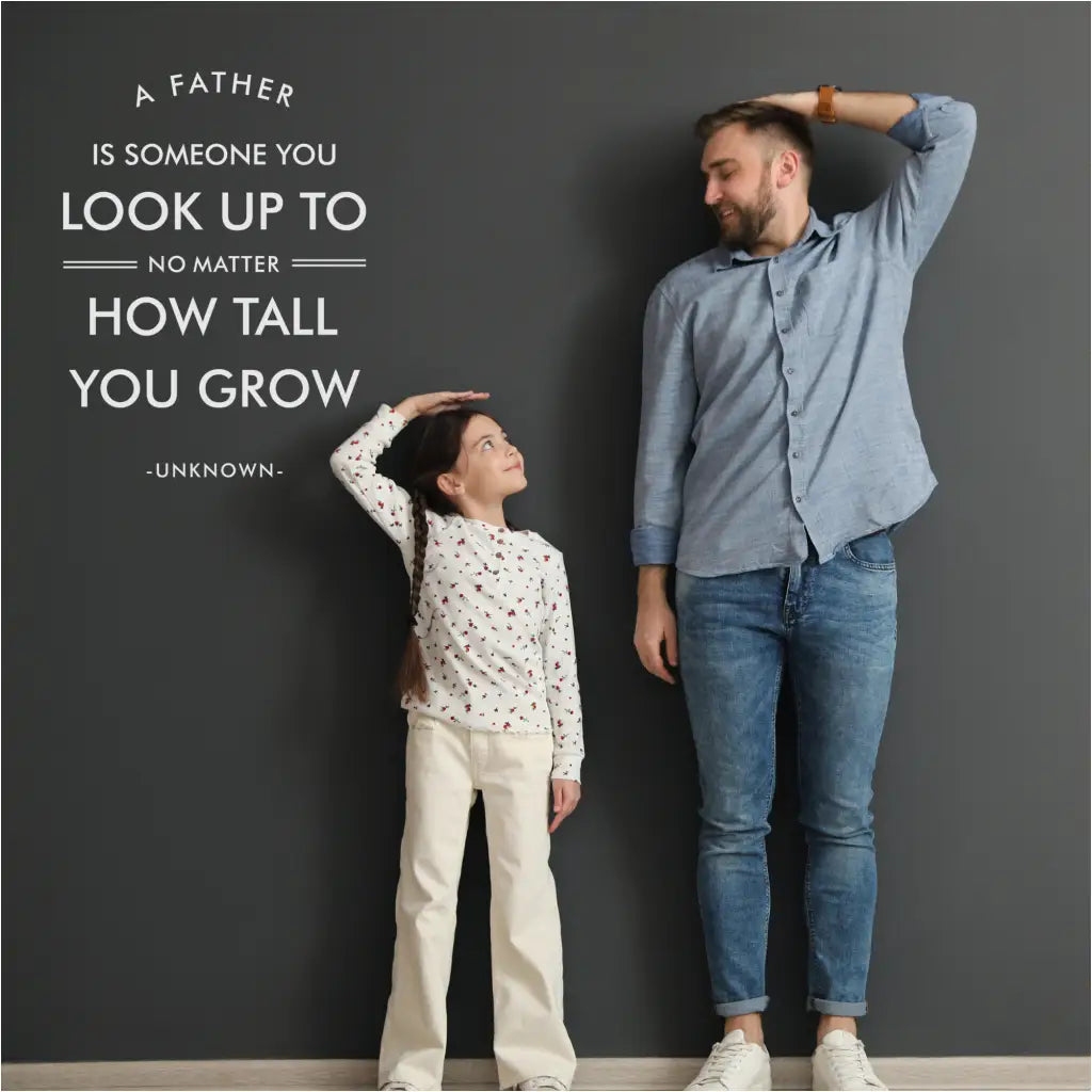 Family celebrates Father's Day with a heartwarming "A father is someone to look up to no matter how tall you grow" wall decal displayed in the background. By TheSImpleStencil.com