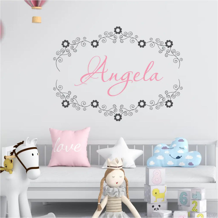 Flower Frame Custom floral name wall decal featuring "Angela" encircled by swirly vines and flowers in a nursery.
