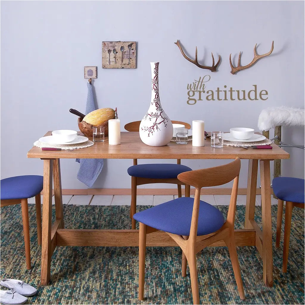 with gratitude - a simple vinyl wall decal by The Simple Stencil displayed over a dining room table next to deer antler display.