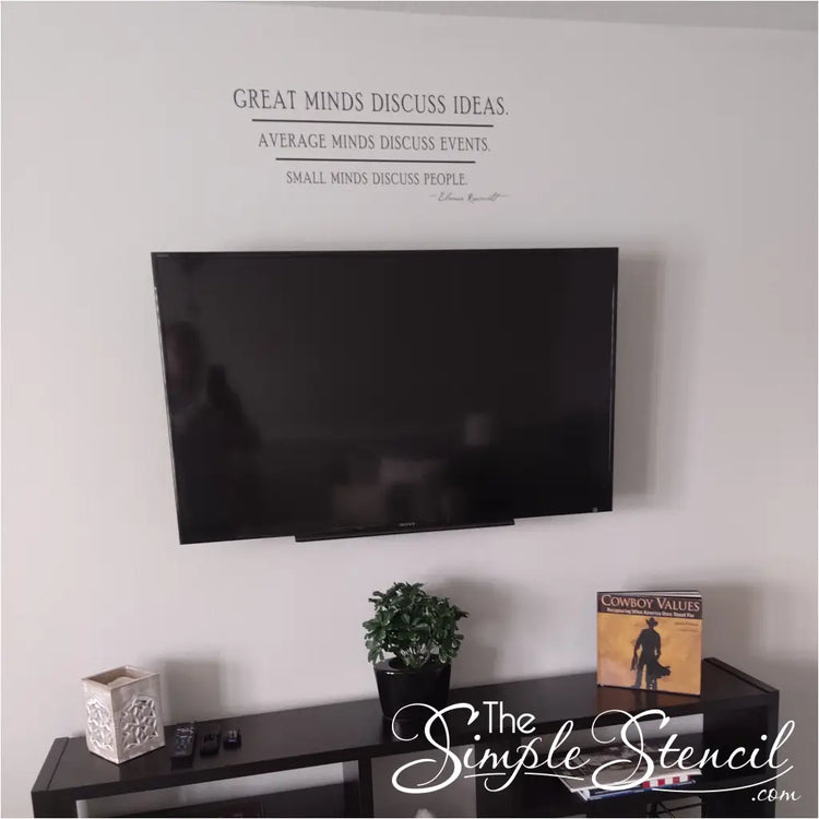 A picture of Eleanor Roosevelt's quote applied to a wall over a television in a family room. Decal reads: Great minds discuss ideas, average minds discuss events. Small minds discuss people.