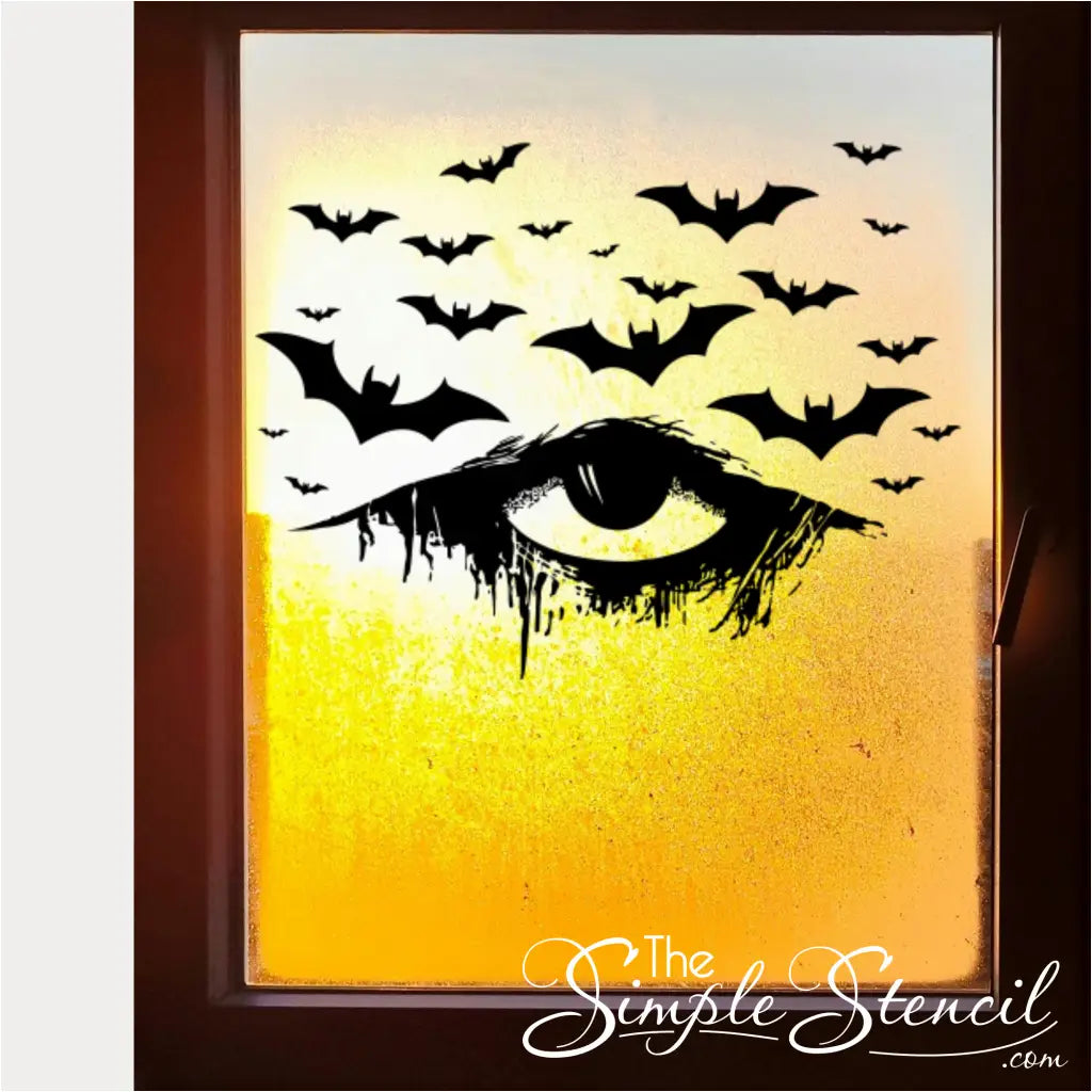 A black vinyl Halloween decal of a distressed, dripping eye with bats, applied to a frosted glass window or panel. The decal stands out sharply against the opaque background, adding a mysterious and elegant touch.