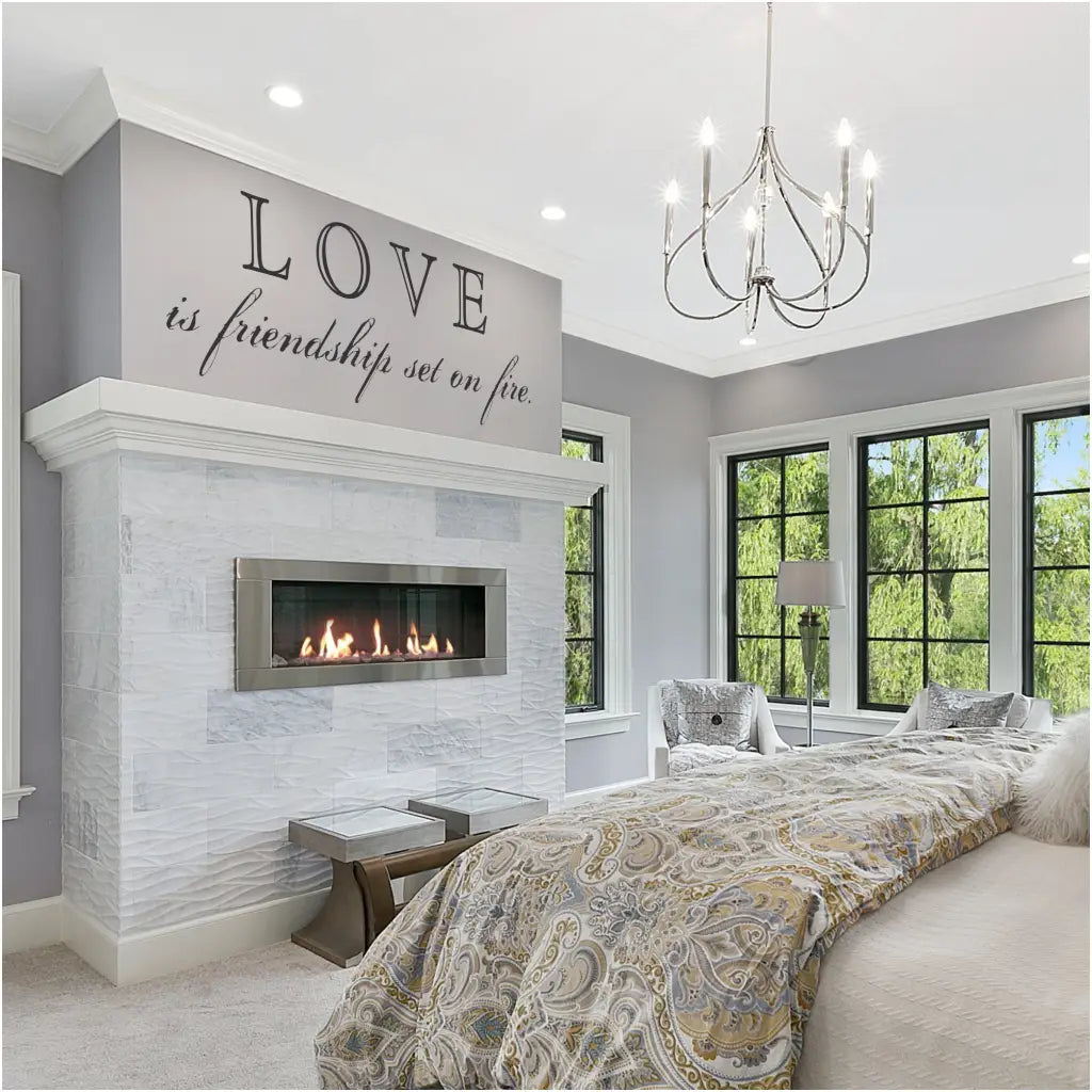 Romantic master bedroom suite in neutral colors help this SimpleStencil wall decal stand out beautifully when placed over the fireplace that reads: Love is friendship set on fire. Very Romantic!!!