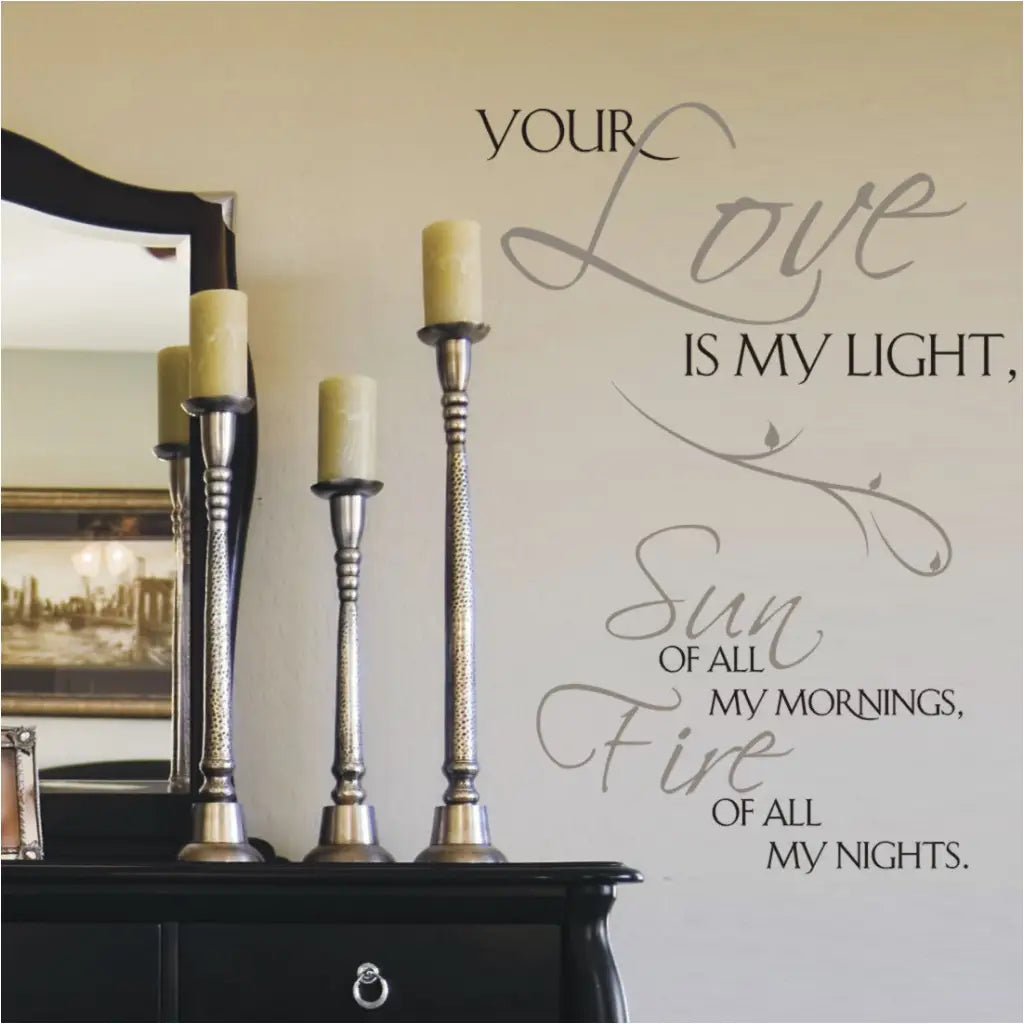 A romantic wall decal displayed next to a master bedroom dresser with candles that appropriately reads: Your love is my light, Sun of all my mornings, Fire of all my nights.
