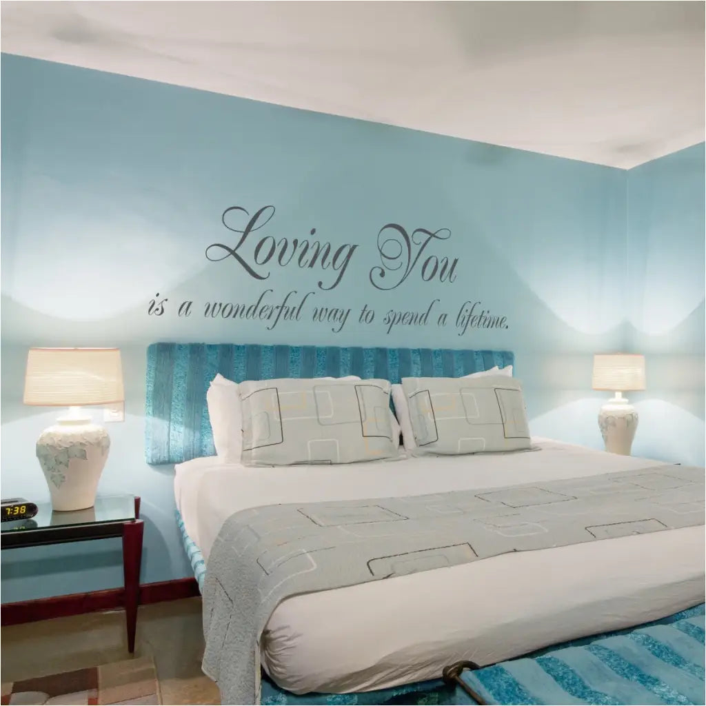 Beautiful vinyl wall decal installed over master bed and reads: Loving you is a wonderful way to spend a lifetime. By TheSimpleStencil.com