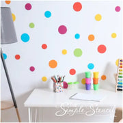 Easy peel and stick polka dot wall decals by The Simple Stencil transform your child's room or playroom in minutes. Colorful bedroom desk pic shows has bright colorful circles that add a whimsical touch of decor.