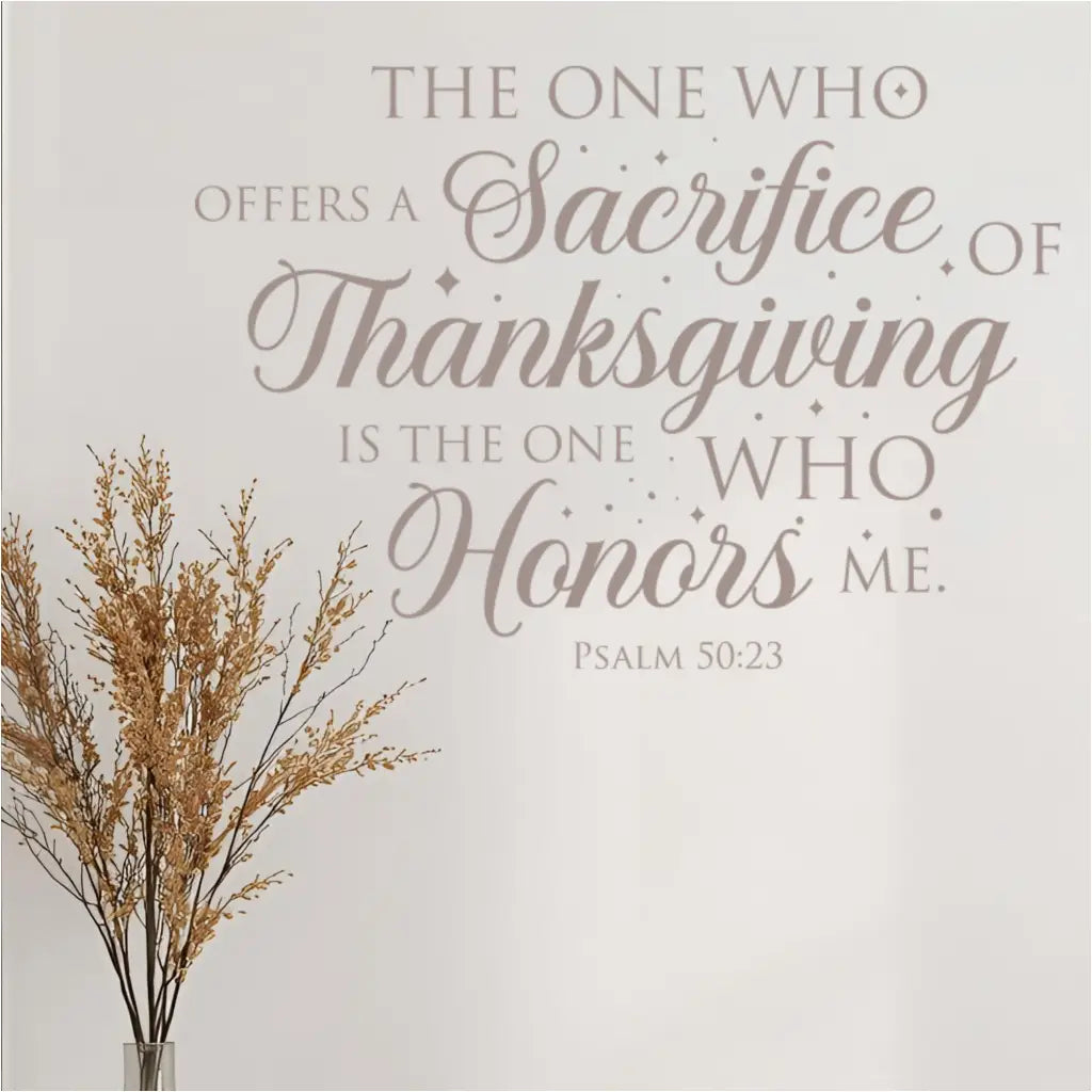 A light taupe version of the Psalm 50:23 bible verse decal is displayed on a wall next to a vase with dried wheat, creating a neutral and minimalist fall decor look.