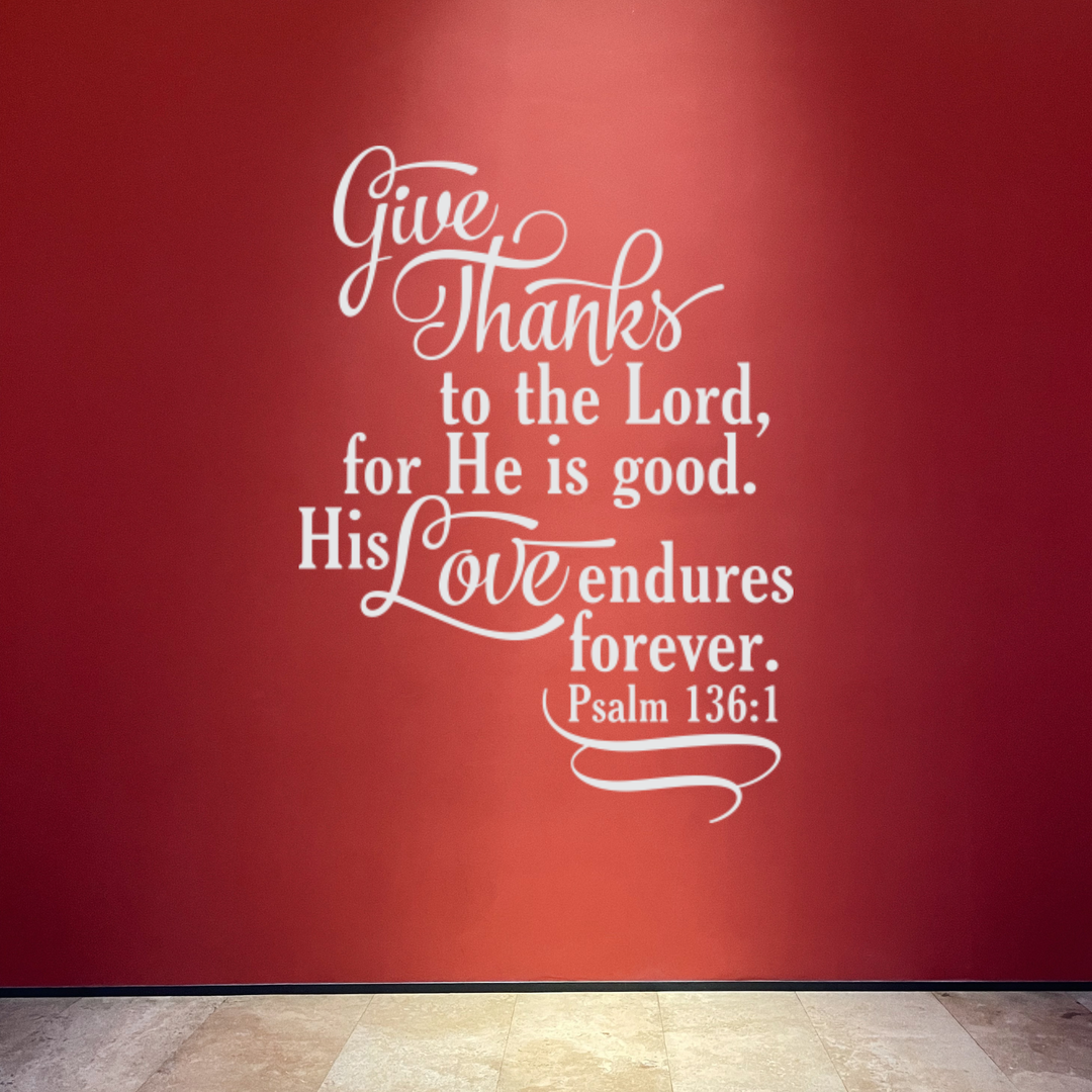 "His Love Endures Forever" decal in bright white, creating a powerful, high-contrast focal point on a vibrant red accent wall.