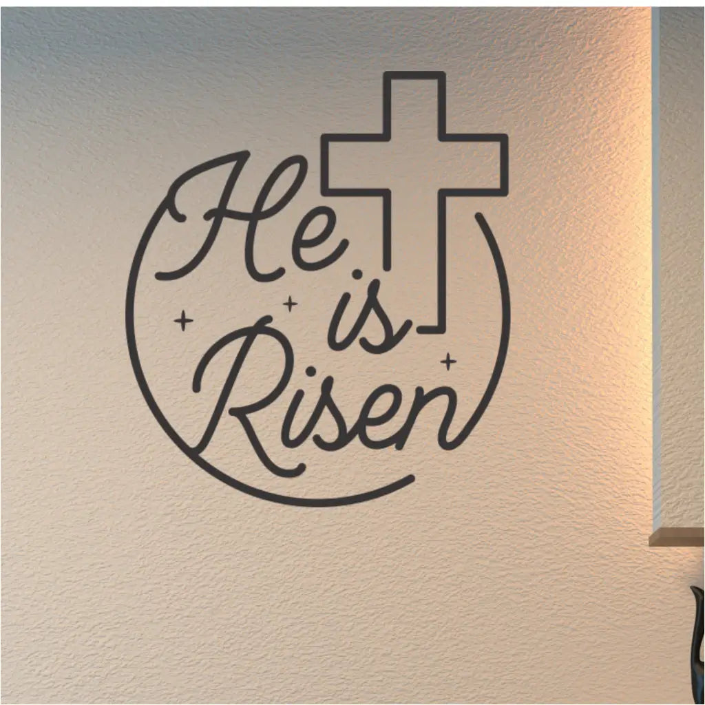 "He is risen" wall decal in black on a church wall, featuring a cross graphic.