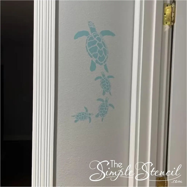 Coastal home decor: Self-adhesive wall art with a family of swimming sea turtles.
