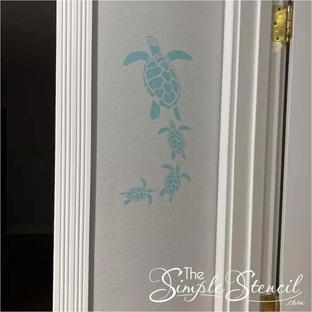 Coastal home decor: Self-adhesive wall art with a family of swimming sea turtles.