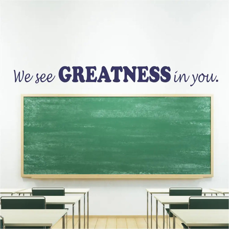 We see GREATNESS in you. A vinyl wall decal installed over a school classroom chalkboard to encourage students and let them know you believe in them. Available in many colors to match your decor or color scheme by The Simple Stencils for schools.