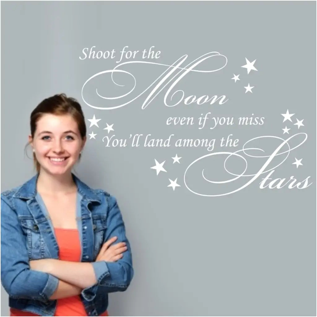 An adorable white vinyl wall decal to inspire students reads: Shoot for the moon, even if you miss you'll land among the stars.