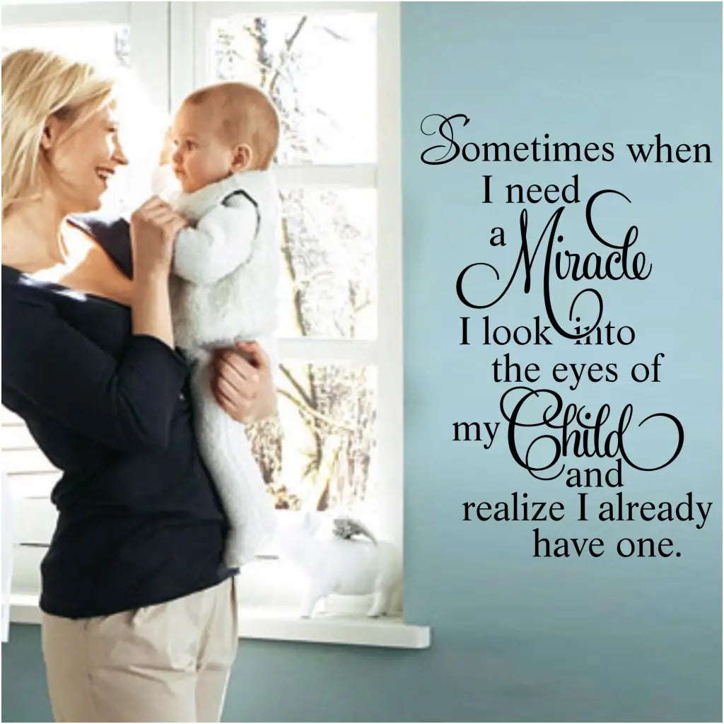 A cute vinyl wall decal by The Simple Stencil displayed on a baby's nursery wall reads: Sometimes when I need a miracle I look into the eyes of my child and realize I already have one. 