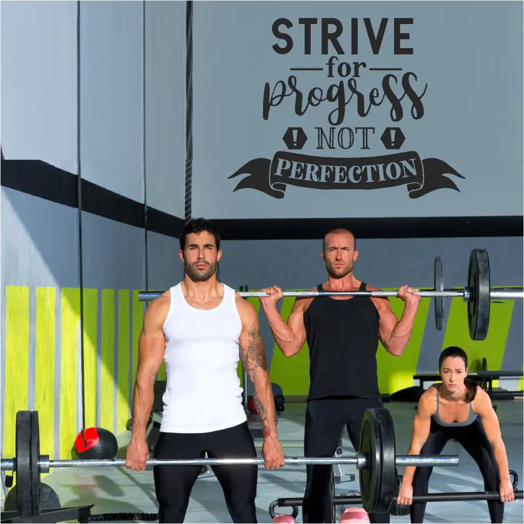 A large wall quote decal displayed on a fitness center gym wall reads: Strive for progress, not perfection