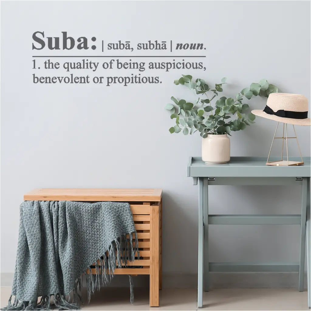 A charcoal gray vinyl wall decal featuring the definition of "Suba," a Sanskrit word for auspiciousness, benevolence, and good fortune, displayed on a family room wall near the entrance. By The Simple Stencil