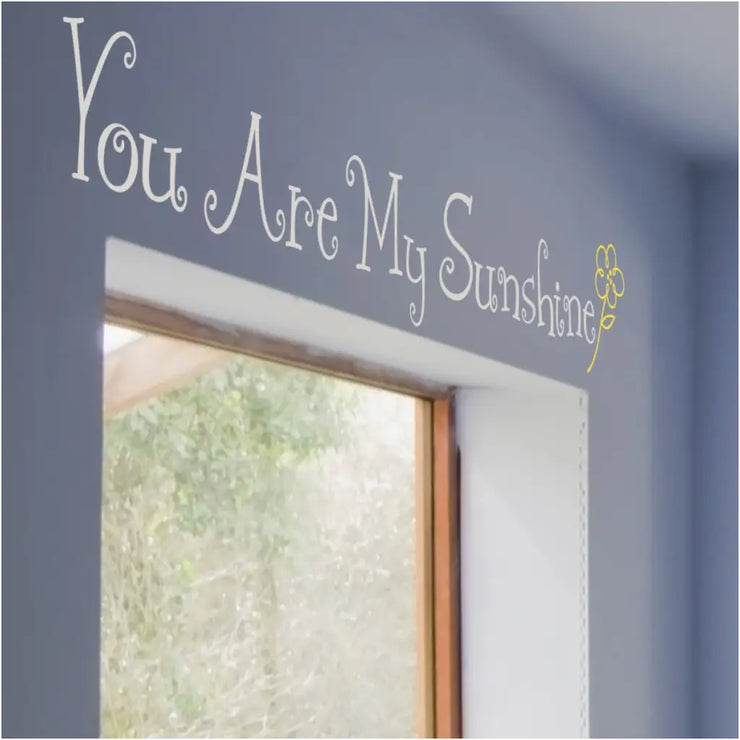 You Are My Sunshine | Adorable vinyl wall decal with sweet flower graphic by The Simple Stencil shown displayed over window in baby nursery.