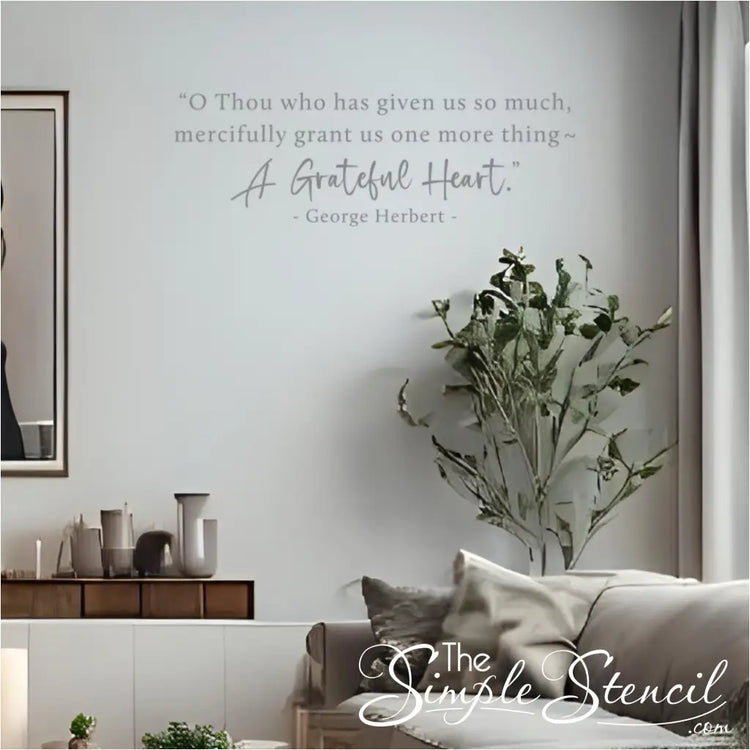 The "A Grateful Heart" religious wall decal displayed in a serene, modern living room next to a framed picture and houseplant.