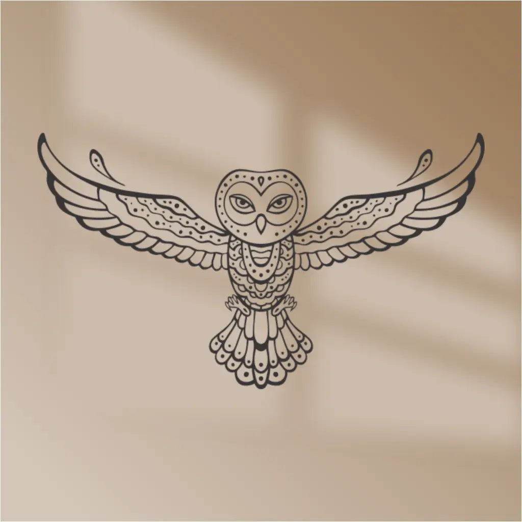 A black tribal owl vinyl wall decal on a beige background, with a shadow from a window casting a pattern on the wall.
