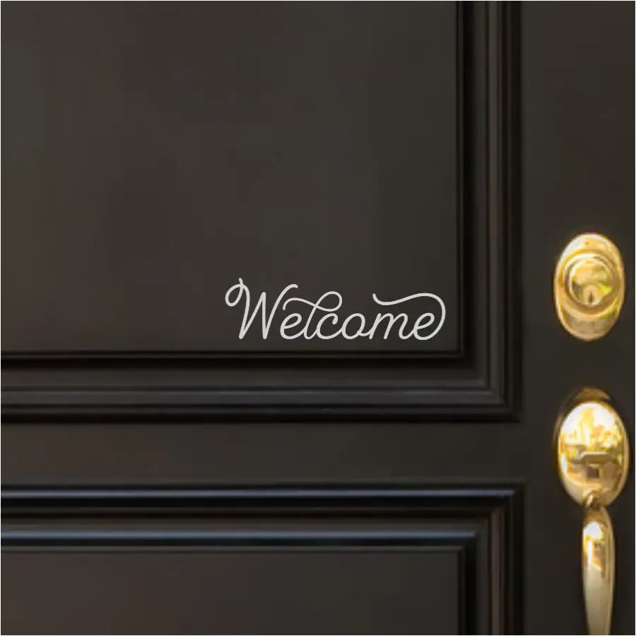 Cute style scripted welcome decal in white applied to a black front door greets guests in a classic black/white stylish way. 