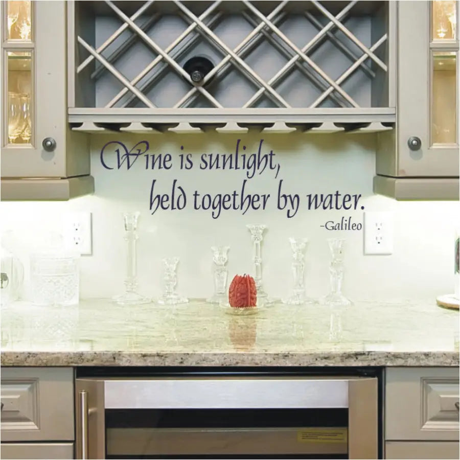 Wall quote decal by Galileo to decorate a wine cellar or near a wine rack. Reads: Wine is sunlight held together by water.