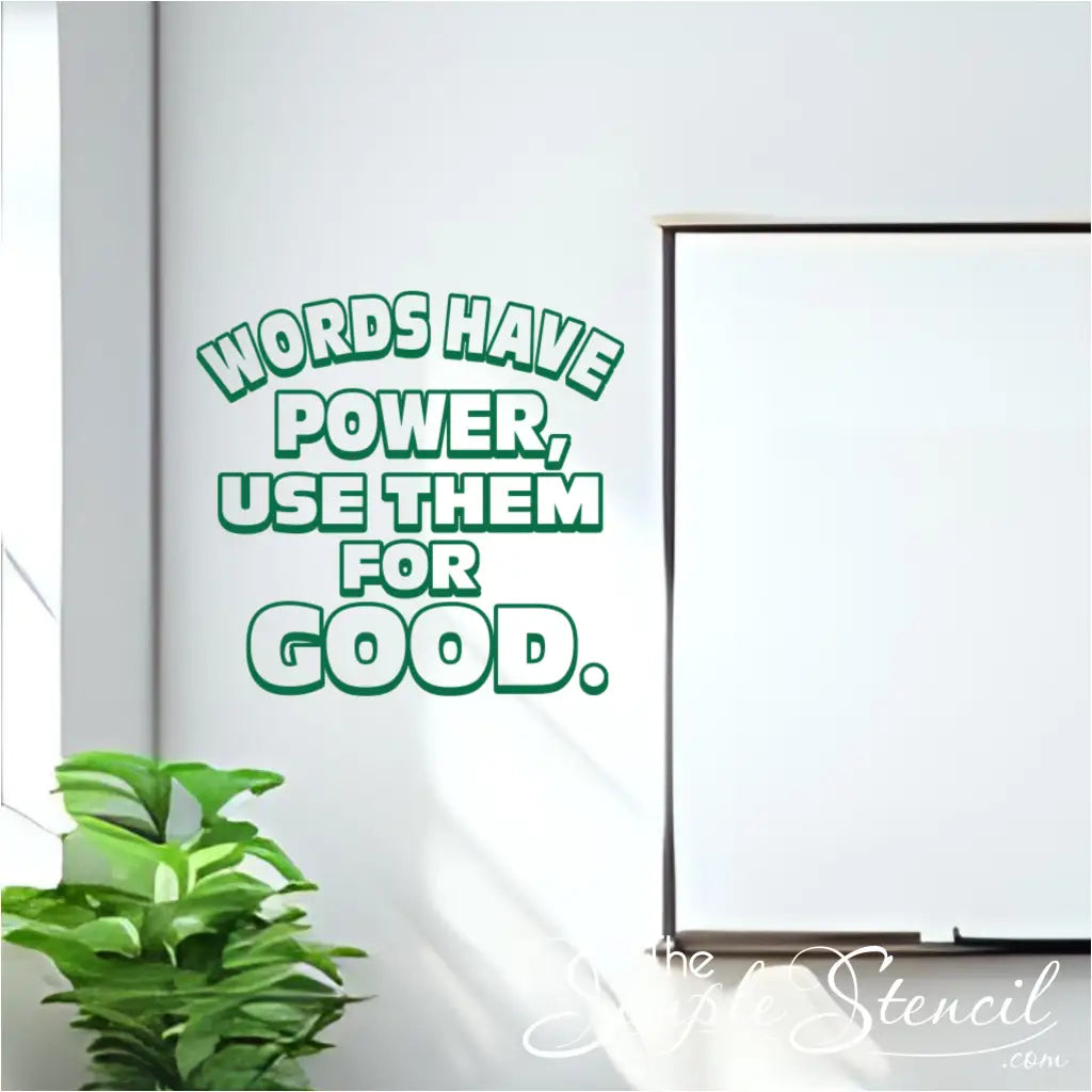 Bright green "Words Have Power, Use Them For Good" vinyl wall decal applied to a white wall next to a window and a green plant, with a blank whiteboard on the right, showcasing classroom positivity decor.