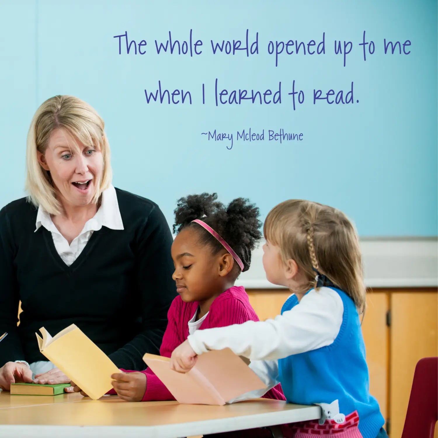 Teacher reading to students with a Simple Stencil wall decal: "The whole world opened up to me when I learned to read" displayed on library walls