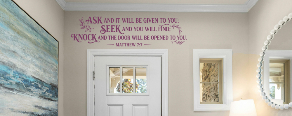Matthew 7:7 custom bible verse vinyl wall lettering layout installed as welcoming wall quotes for church lobby entrances or home entryways, positioned beautifully on a neutral wall directly above a white multi-panel interior door.