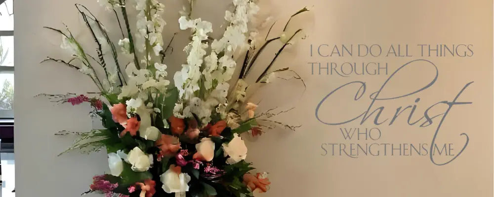 Philippians 4:13 Bible verse wall decal featuring 'I can do all things through Christ who strengthens me' in elegant script, displayed next to a floral arrangement.