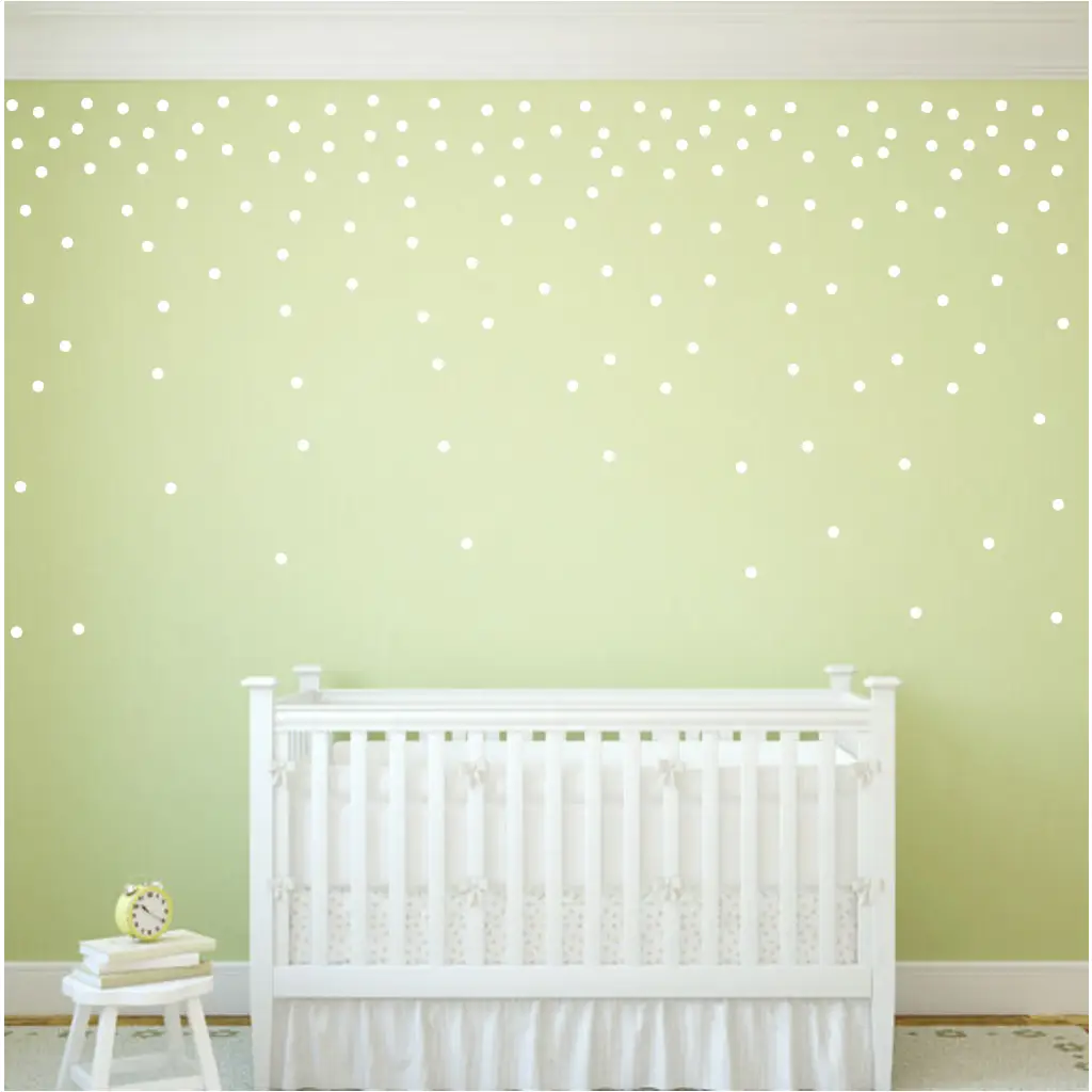 Peel and stick vinyl wall polka dots added to a baby's nursery wall creates a confetti pattern. Shown in white polka dots on green wall with a set of 112 - 1.5"  circles by The Simple Stencil