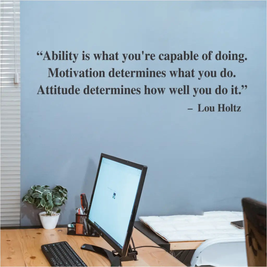 Lou Holtz motivational wall decal applied to a home office wall where it can inspire everyday. Reads: Ability is what you're capable of doing. Motivation determines what you do. Attitude determines how well you do it. Lou Holtz