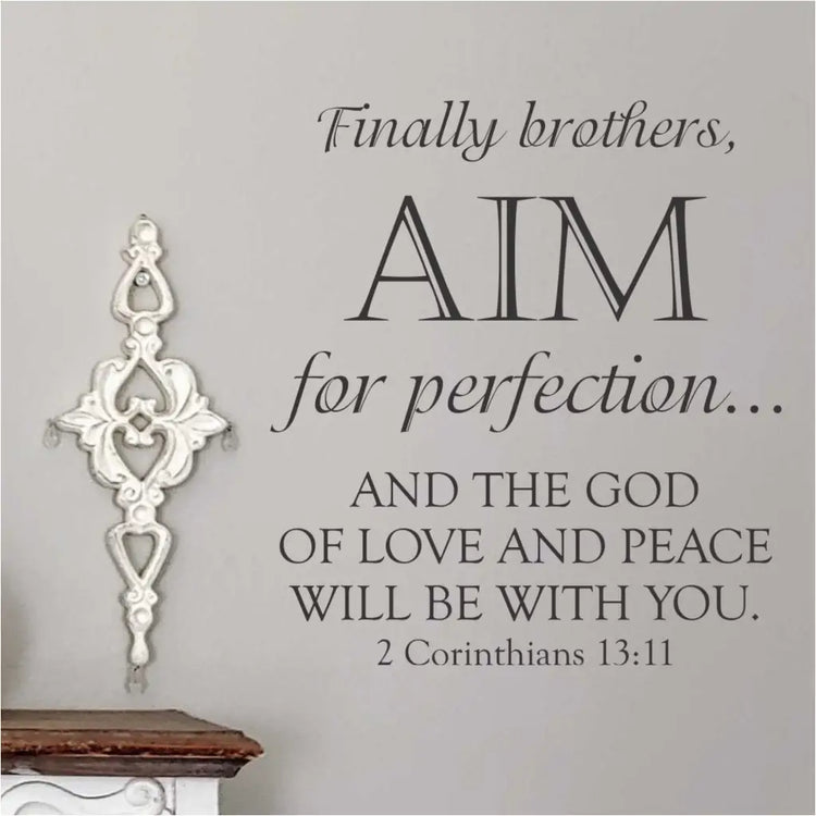 Aim For Perfection 2nd Corinthians 13:11 Bible Verse Wall Decor Decal shown on a church wall in the vinyl color black sized 18" x 20" By The Simple Stencil