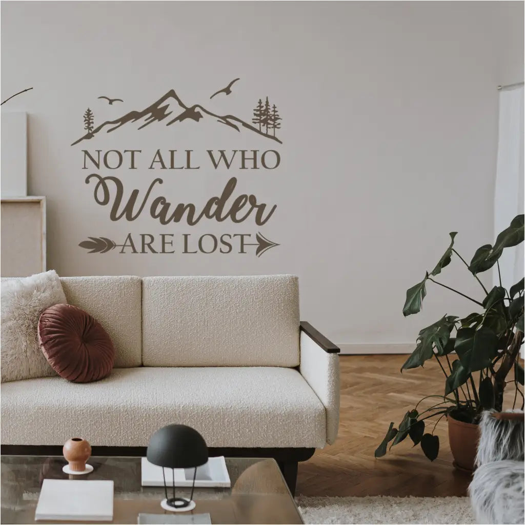 Not all who wander are lost - A quote from J.R.R. Tolkien's Poem created into a beautiful wall decal display with a mountain top and whimsical arrow graphic. Shown in chocolate brown on a family room wall.