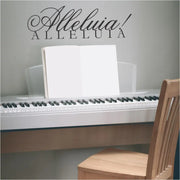 Alleluia! wall art decal by The Simple Stencil displayed over a practice piano keyboard. 
