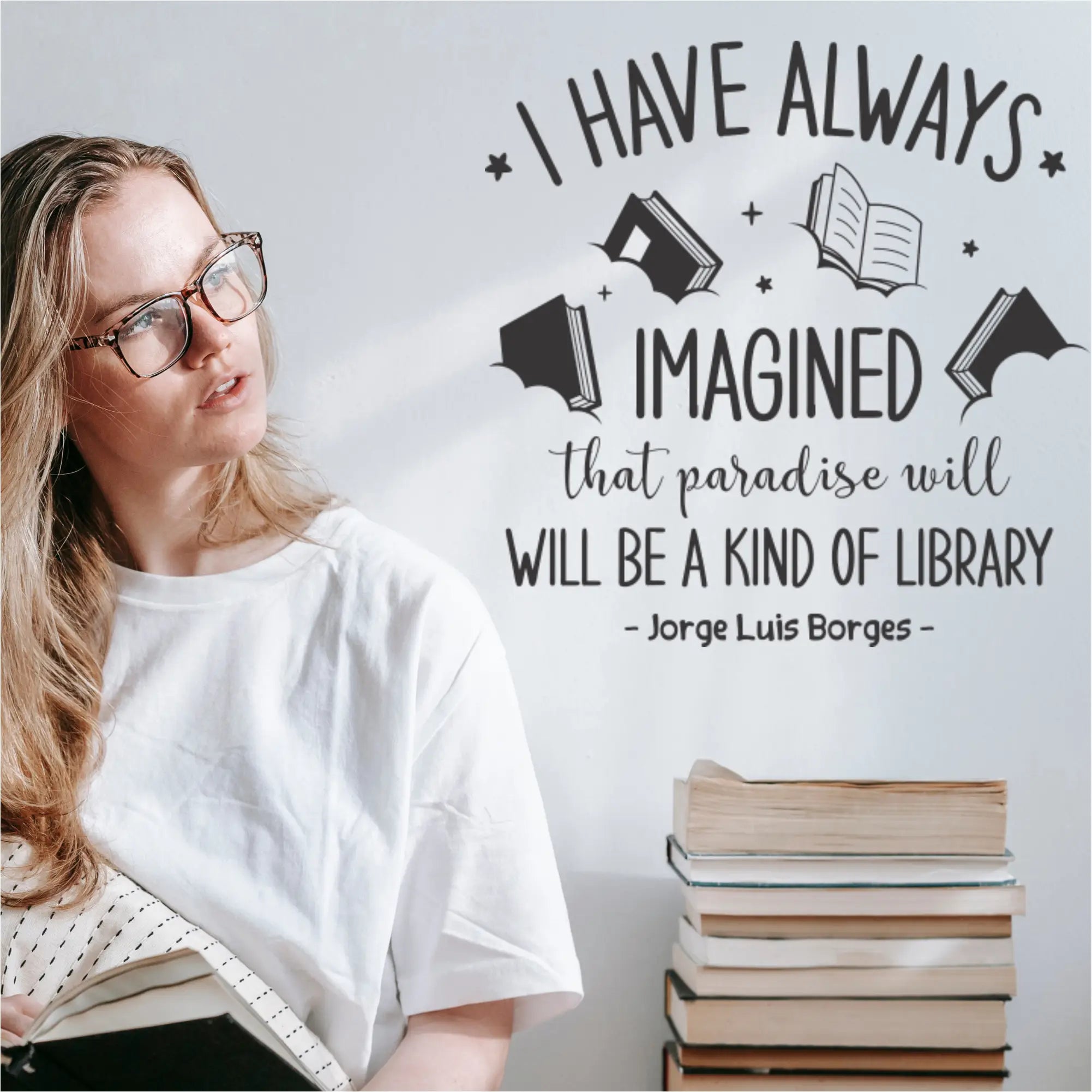 "I have always imagined that paradise will be a kind of library" wall decal in [Color] on a library wall, featuring book, star, and cloud graphics.