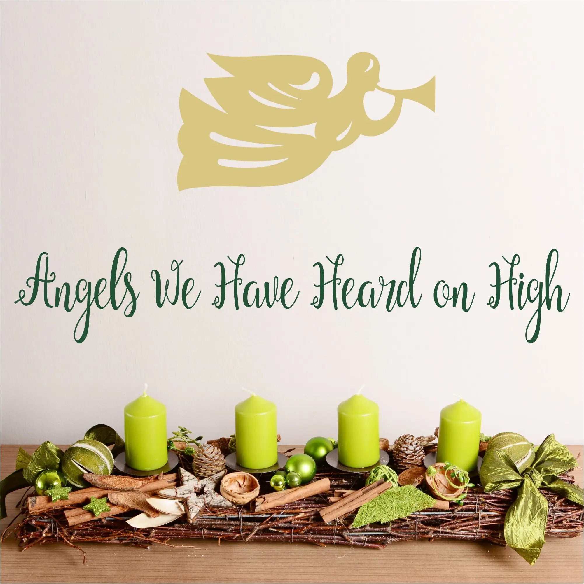 Angels we have heard on high - a pretty script wall decal displayed on a wall near christmas decor with a heralding angel graphic placed above by The Simple Stencil Christmas Decals
