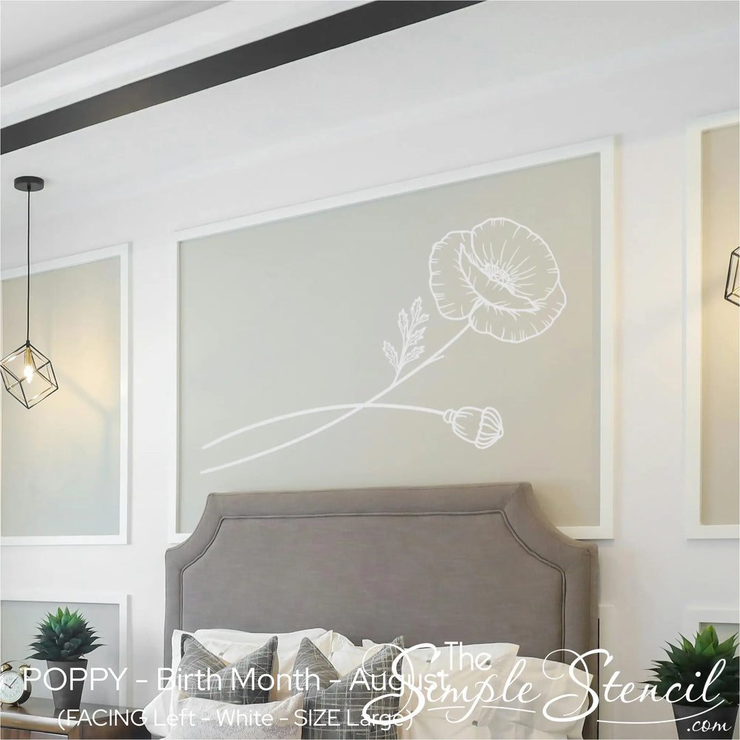Large white Poppy birth flower wall accent applied horizontally over a modern upholstered headboard in a bright bedroom.