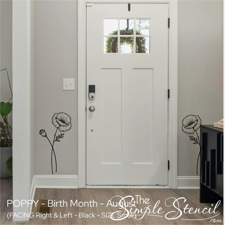 Two small black Poppy wall accents framing a white front door in a minimalist, welcoming entryway.