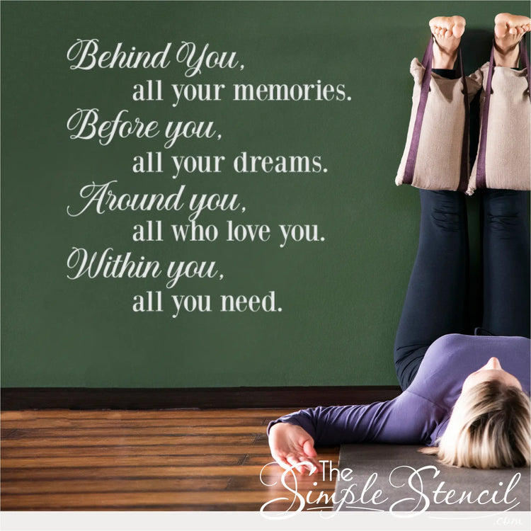A calming, wellness-focused room featuring a woman practicing a relaxing yoga pose with her legs up against a deep green wall. On the flat wall surface next to her, the premium matte white vinyl lettering is cleanly applied, showcasing the daily affirmation quote in a beautifully aligned vertical design.
