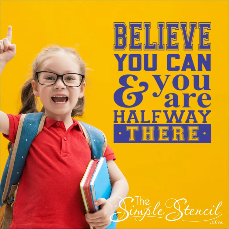 Inspiring wall decal showcasing the positive classroom quote 'Believe You Can and You're Halfway There' beautifully displayed in a classroom setting next to an inspired student. Picture and decal by The Simple Stencil