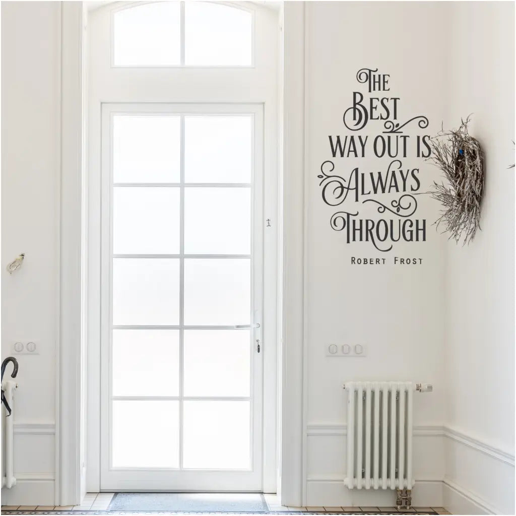  A vinyl wall decal displaying the quote by Robert Frost, "The Best Way Out Is Always Through," showcased near a doorway in a foyer. The elegant decal serves as an inspiring reminder to face challenges with determination and resilience. Wall Decal By The Simple Stencil