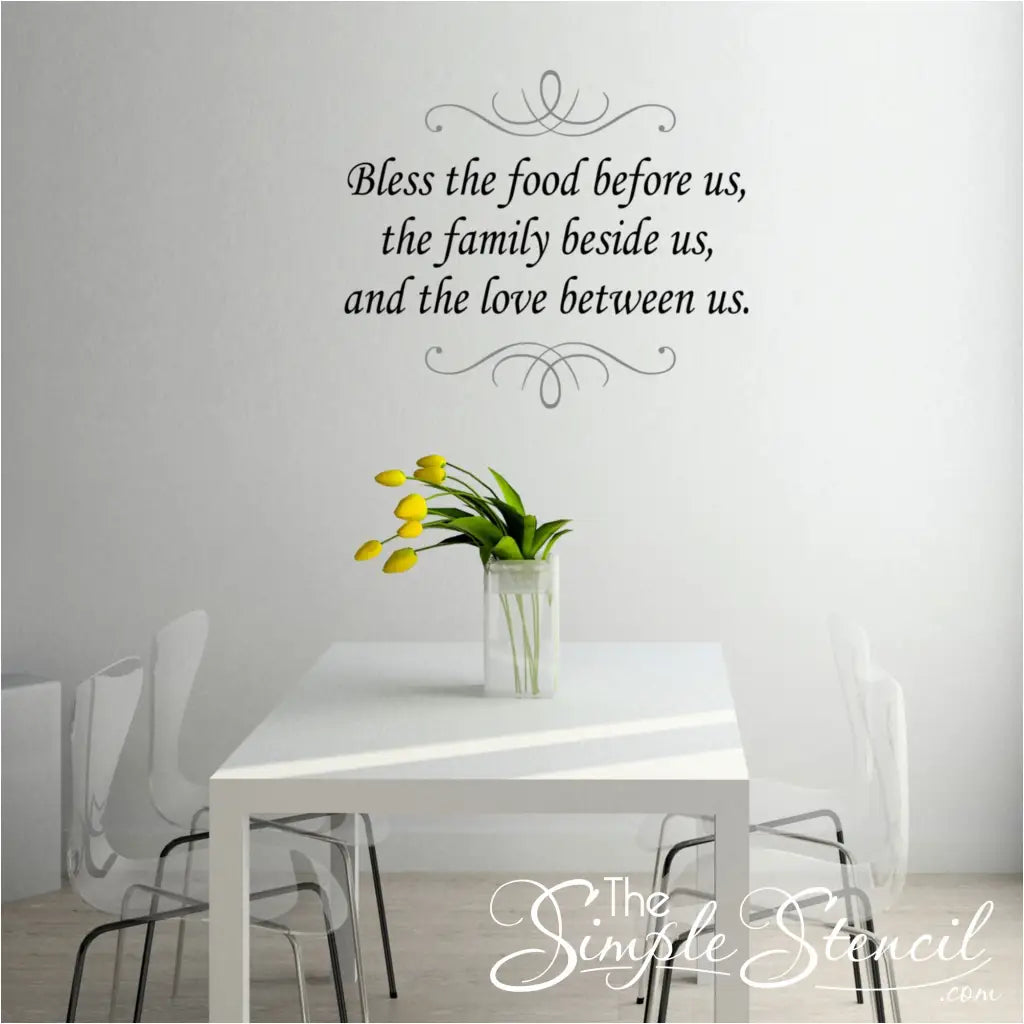 Bless the Food Before Us wall decal installed in a dining room above a modern table ready to be set for Thanksgiving dinner.