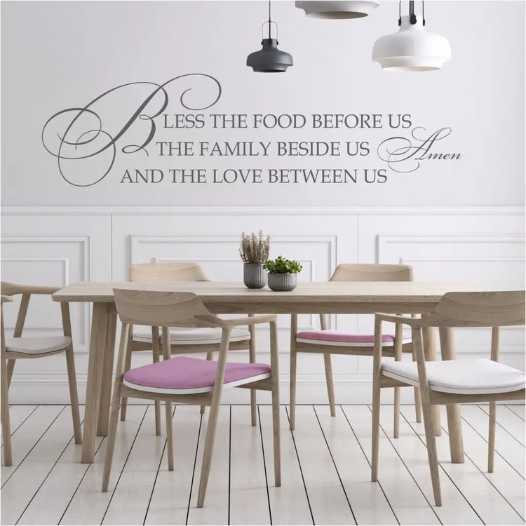 A beautifully scripted wall decal that quotes: Bless the food before us, the family beside us and the love between us. Amen. - By The Simple Stencil