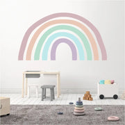 Large pastel rainbow wall decal mural displayed on a wall in a child's playroom to add a sweet touch of color to room decor. Custom colors and many sizes available at TheSimpleStencil.com